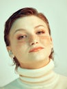 Pretty young redhead short haired girl looking at camera with friendly smile, studio portrait of female with freckles Royalty Free Stock Photo