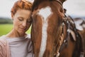 Pretty, young, redhead woman with her lovely horse