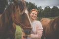 Pretty, young, redhead woman with her lovely horse