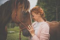 Pretty, young, redhead woman with her lovely horse