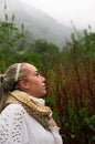 Pretty young reflective woman looking up in a mountain