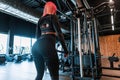 Pretty young sexy fitness woman with beautiful slim body doing exercises in the gym, back view Royalty Free Stock Photo