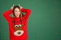 Pretty young singaporean girl wearing Christmas jumper and doing Royalty Free Stock Photo