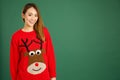 Pretty young singaporean girl wearing Christmas jumper and smiling