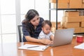 Pretty young single mom working at home on a laptop computer, and baby daughter need her attention. Mother play on laptop with Royalty Free Stock Photo