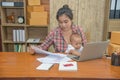 Pretty young single mom working at home on a laptop computer while holding her baby girl sitting on her lap enjoying watching Royalty Free Stock Photo