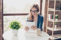 Pretty young smiling woman using digital tablet and having break in a cafe Royalty Free Stock Photo