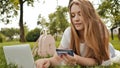 Pretty young student girl makes purchases online using a credit card and laptop computer. Royalty Free Stock Photo