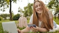 Pretty young student girl makes purchases online using a credit card and laptop computer. Royalty Free Stock Photo