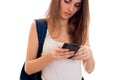 Pretty young students girl with blue backpack on shoulder and mobile phone in hands posing isolated on white background Royalty Free Stock Photo