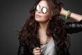 Pretty young stylish girl in leather jacket and round sunglasses Royalty Free Stock Photo