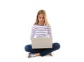 Pretty young teen girl sitting on the floor with crossed legs and using laptop, Royalty Free Stock Photo