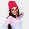 Pretty young teenage girl hipster in pink glasses and hat emotional posing happy smiling, lifestyle people concept Royalty Free Stock Photo