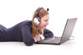 Pretty young teenage girl with laptop and headphones lying on the floor Royalty Free Stock Photo