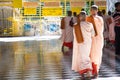 Pretty young teenage nuns in pink uttarasanga visiting Shwethalyaung reclining buddha temple in Bago Pegu, Myanmar