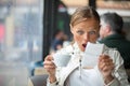 Pretty, young woman baffled with the bill in a coffeeshop