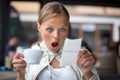 Pretty, young woman baffled with the bill in a coffeeshop