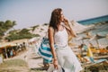 Pretty young woman with a bag using mobile phone on the beach Royalty Free Stock Photo