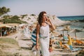 Pretty young woman with a bag using mobile phone on the beach Royalty Free Stock Photo