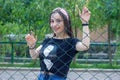 Pretty young woman behind fence, young woman in a park Royalty Free Stock Photo