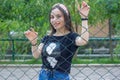 Pretty young woman behind fence, young woman in a park Royalty Free Stock Photo