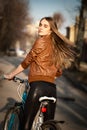 Pretty young woman with bicycle in a city road