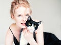 Pretty young woman with black cat in blanket Royalty Free Stock Photo