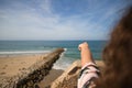 Pretty young woman, blonde with curly hair and blue eyes is pointing with her index finger to the ocean horizon. The woman has the Royalty Free Stock Photo