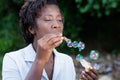 Pretty young woman blowing bubbles. Royalty Free Stock Photo