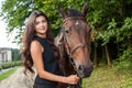 Pretty young woman and a brown horse