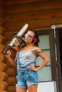 Pretty young woman builder powered chain saw Royalty Free Stock Photo