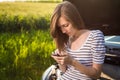 Pretty, young woman calling the roadside service Royalty Free Stock Photo