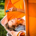 Pretty, young woman camping outdoors, lying in the tent Royalty Free Stock Photo