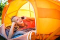 Pretty, young woman camping outdoors, lying in the tent Royalty Free Stock Photo