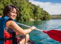 Pretty, young woman on a canoe on a lake