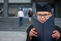 Pretty, young woman celebrating joyfully her graduation Royalty Free Stock Photo