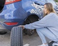 Pretty young woman changing wheel Royalty Free Stock Photo