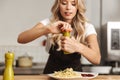 Pretty young woman chef putting salt Royalty Free Stock Photo