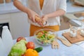 Pretty young woman chef putting salt in a salad Royalty Free Stock Photo