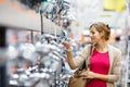 Pretty young woman choosing a bathroom/kitchen tap in a home fur