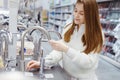 Pretty young woman choosing a bathroom/kitchen tap in a home furnishings retail store Royalty Free Stock Photo