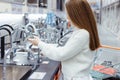 Pretty young woman choosing a bathroom/kitchen tap in a home furnishings retail store Royalty Free Stock Photo