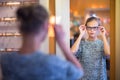 Pretty, young woman choosing new glasses frames Royalty Free Stock Photo