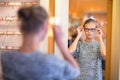 Pretty, young woman choosing new glasses frames Royalty Free Stock Photo