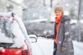 Pretty, young woman cleaning her car from snow Royalty Free Stock Photo