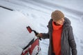 Pretty, young woman cleaning her car from snow Royalty Free Stock Photo