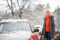 Pretty, young woman cleaning her car from snow Royalty Free Stock Photo