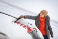 Pretty, young woman cleaning her car from snow Royalty Free Stock Photo