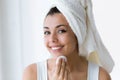 Pretty young woman is cleaning her face while looking in the mirror in the bathroom. Royalty Free Stock Photo