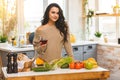 Pretty woman cooking and drinking some wine at home in kitchen